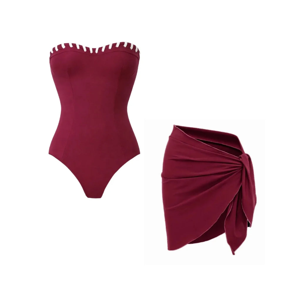 Maroon strapless one-piece swimsuit with white contrast trim, paired with a maroon wrap skirt.