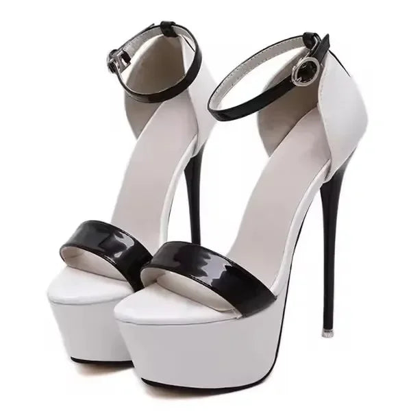White high-heeled platform shoes with black patent leather straps on a white background