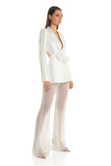 Woman wearing a white blazer and patterned pants