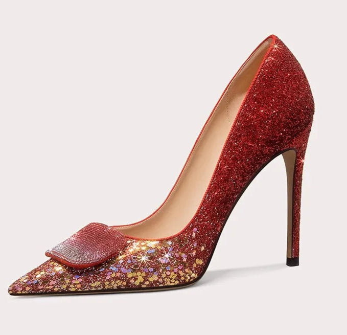 Red glitter high-heeled shoe with a decorative bow on a light gray background