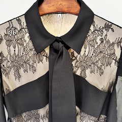 Black lace blouse with a tie collar on a hanger