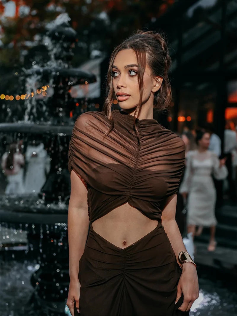 Woman wearing a brown dress with cut-out design in an outdoor setting