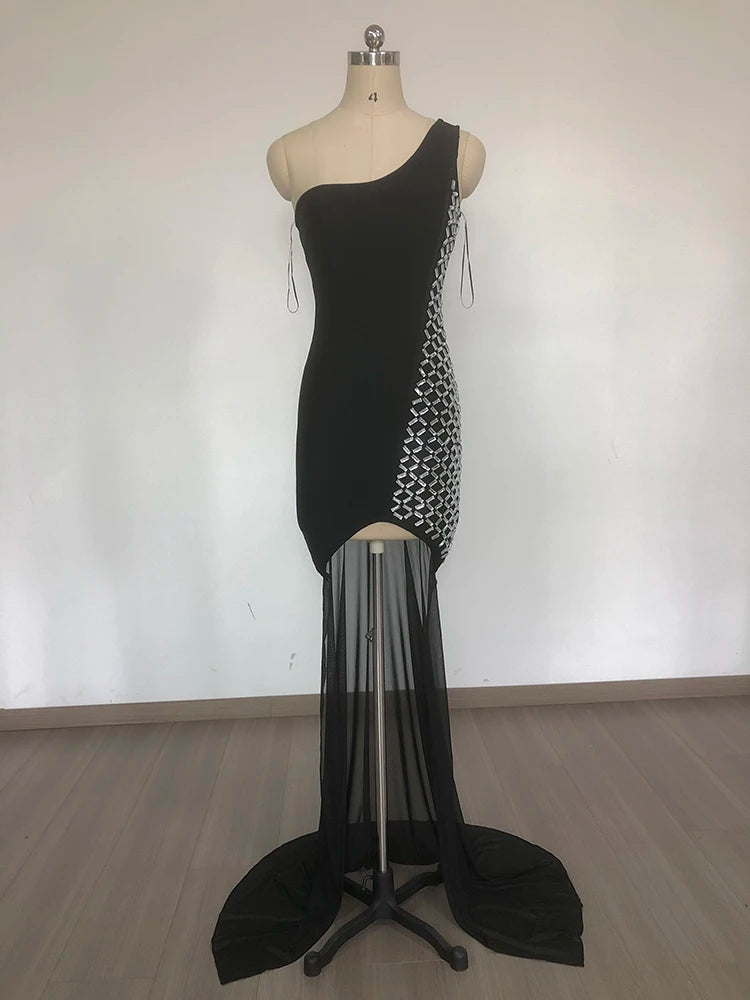 Black one-shoulder dress with sheer overlay on a mannequin against a white background