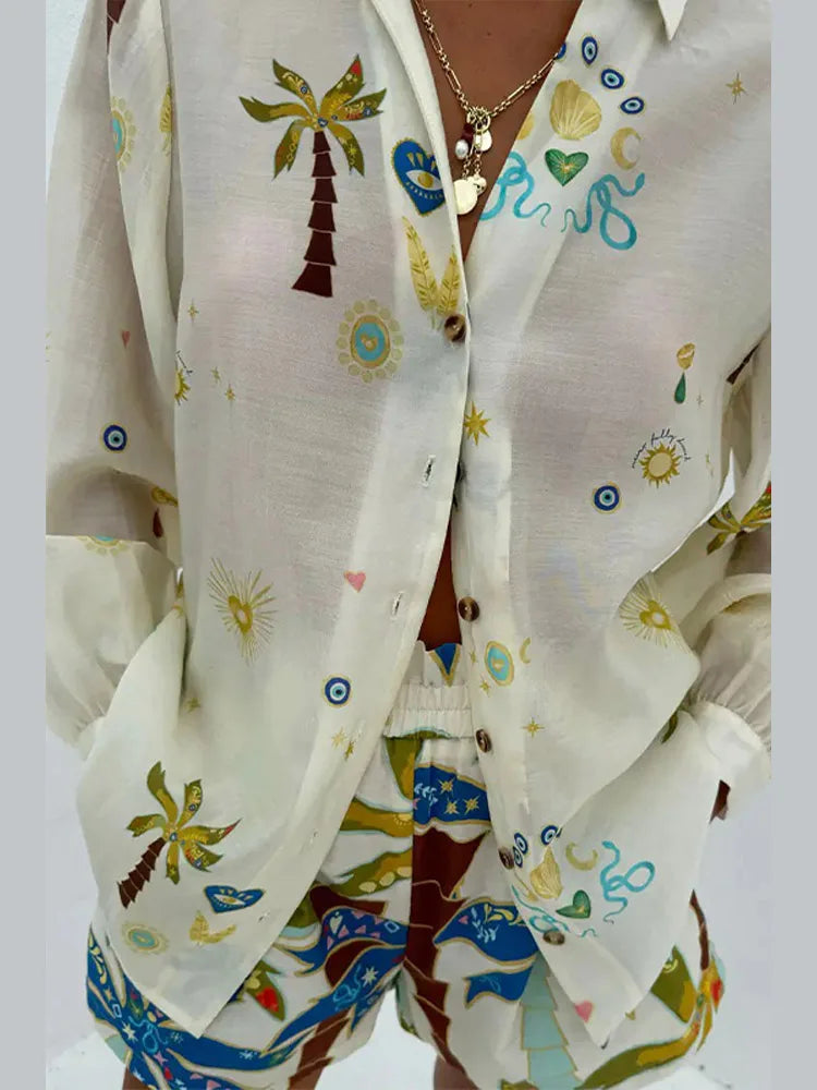 White shirt with colorful palm tree and beach-themed designs on a plain background