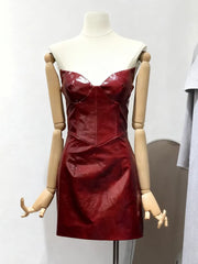 Red leather dress on a mannequin against a plain background