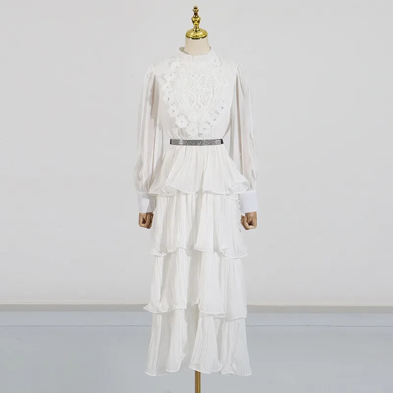 White dress with floral details on a mannequin against a plain background