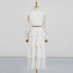 White dress with floral details on a mannequin against a plain background