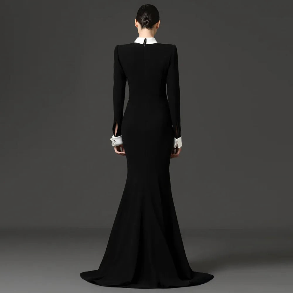 Back view of a black floor-length dress with long sleeves and a white collar.