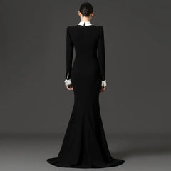 Back view of a black floor-length dress with long sleeves and a white collar.