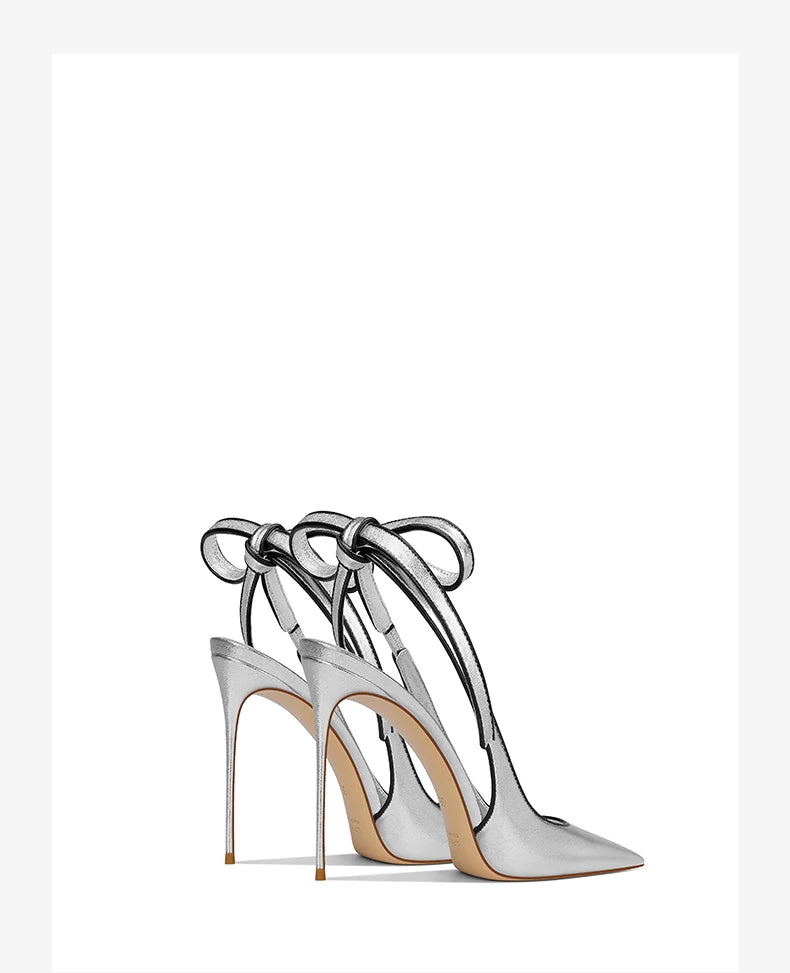 Silver high-heeled shoes with ankle straps on a white background