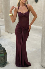 Woman wearing a burgundy evening gown with a halter neckline, standing against a neutral background.
