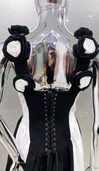 Black dress with floral arm cuffs in front of a reflective surface