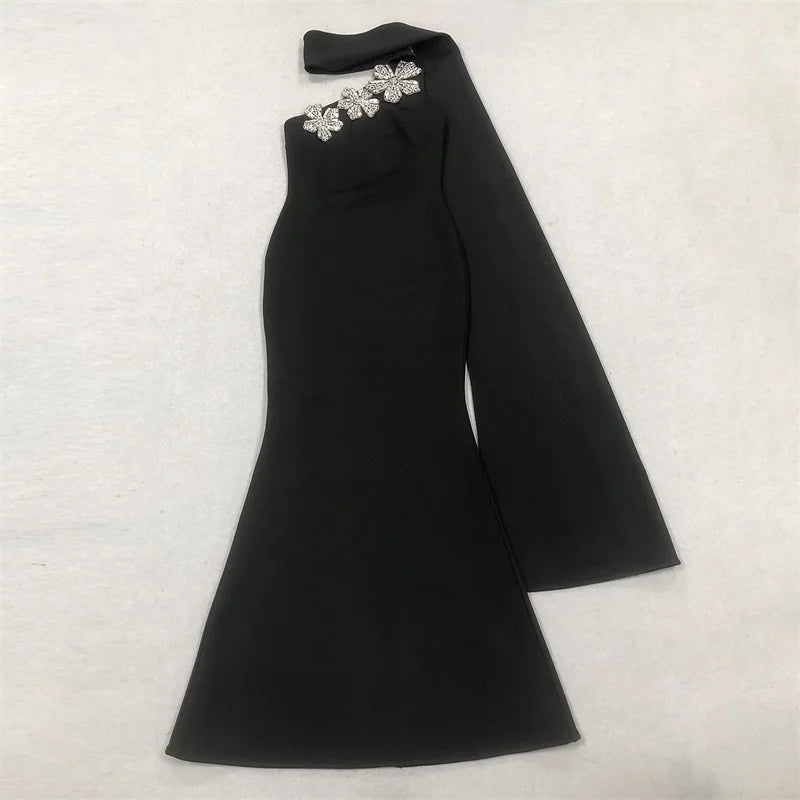 Black one-shoulder dress with floral embellishments on a light gray background