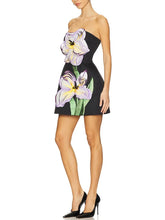 Woman wearing a strapless dress with floral design on a white background