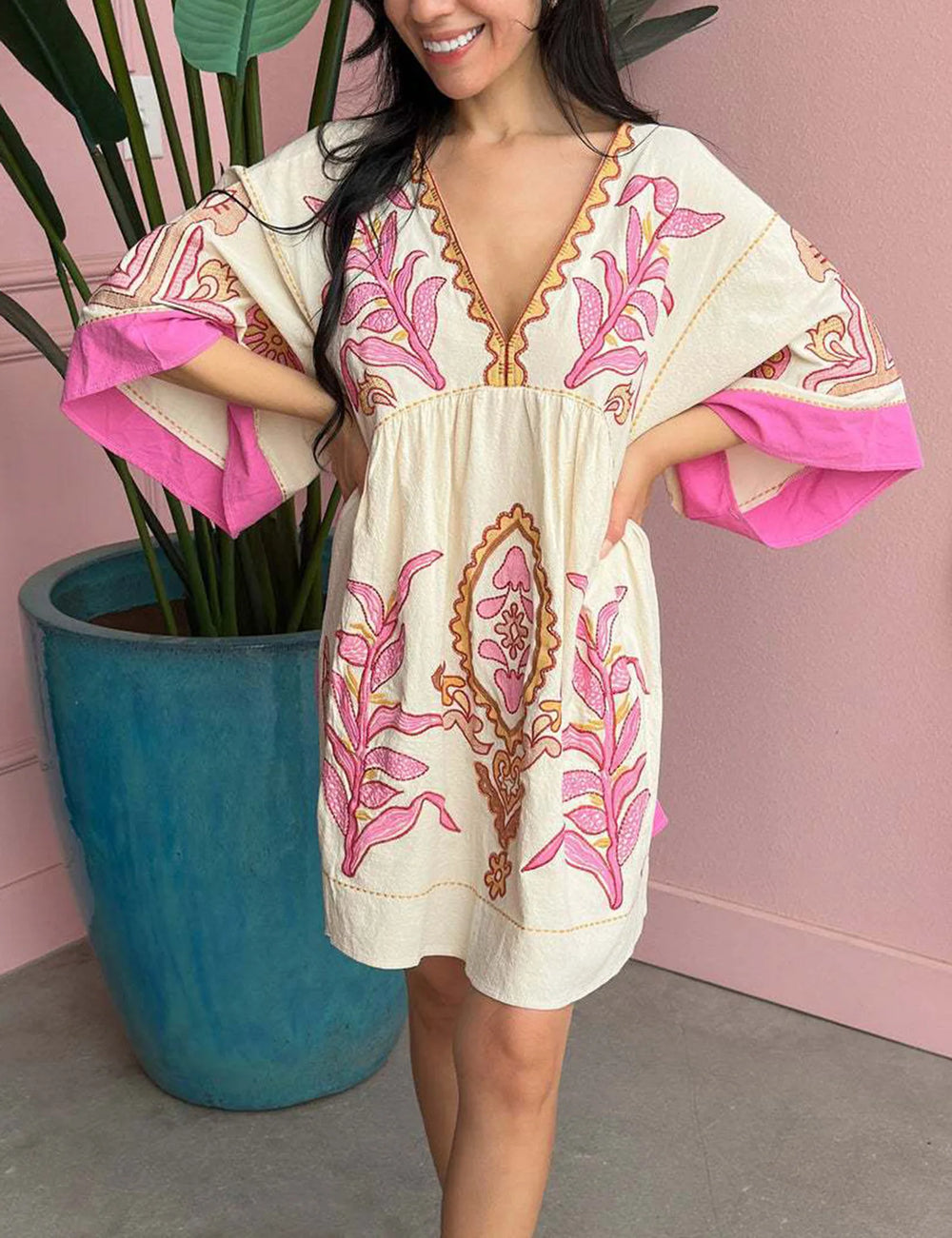 White mini dress with pink floral embroidery and flared sleeves