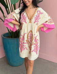 White mini dress with pink floral embroidery and flared sleeves