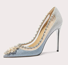 Silver high-heeled shoe with decorative elements on a white background