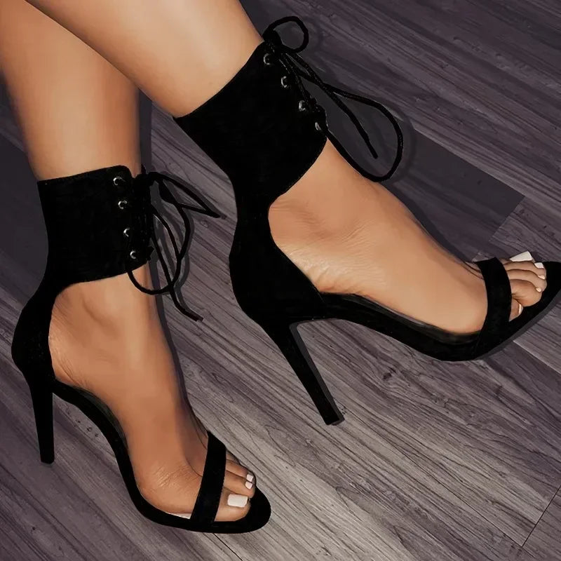 Close-up of black lace-up stiletto heels with open toe