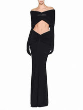 Black off-shoulder draped top and high-waist maxi skirt with long gloves.