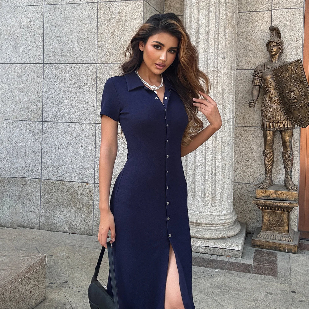 Woman in a navy blue dress standing next to a bronze statue of a warrior.