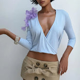 Light blue wrap top with floral shoulder embellishment.