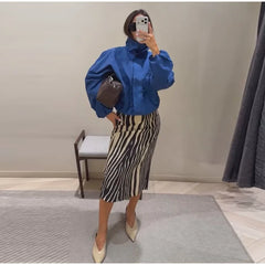 Woman wearing a blue jacket and zebra print straight midi skirt