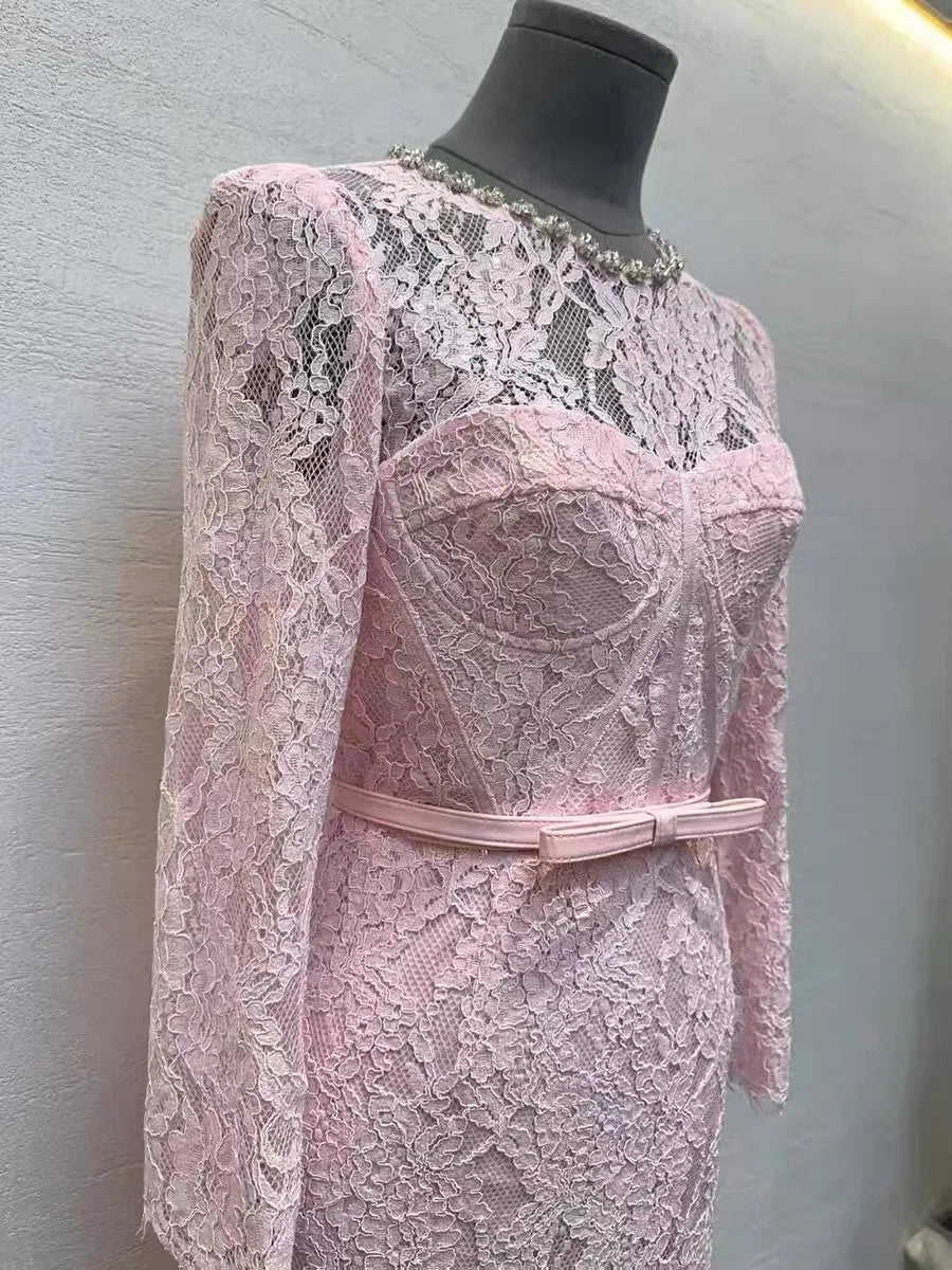 Pink lace dress on a mannequin against a gray background