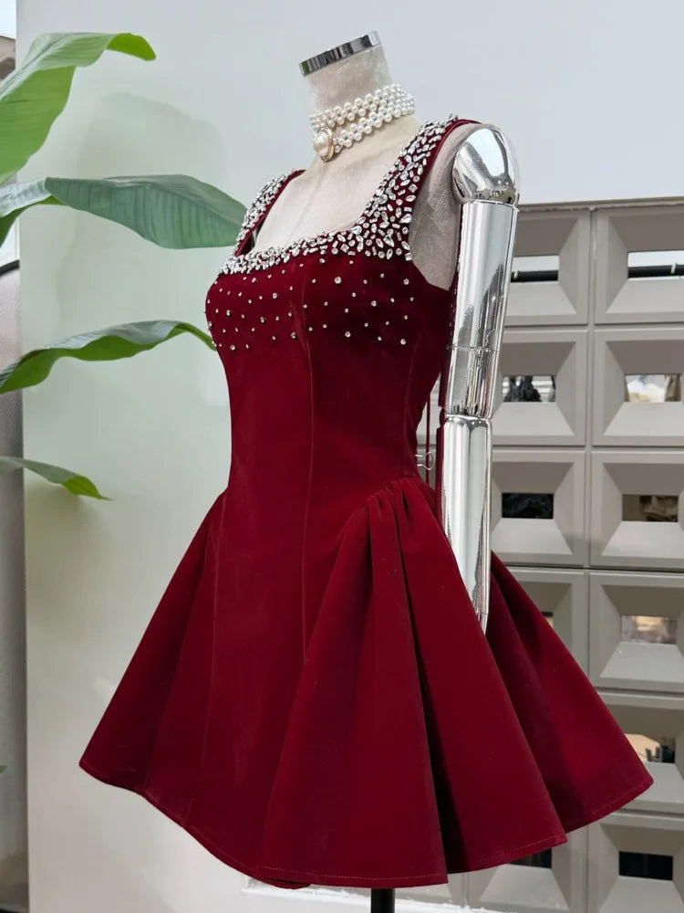 Red dress with pearl embellishments on a mannequin against a neutral background