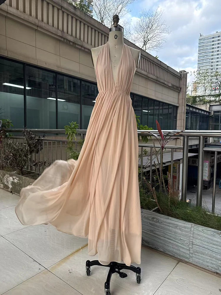 Beige evening gown on a mannequin outdoors with buildings in the background