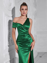 Woman wearing a green one-shoulder dress in an elegant interior setting