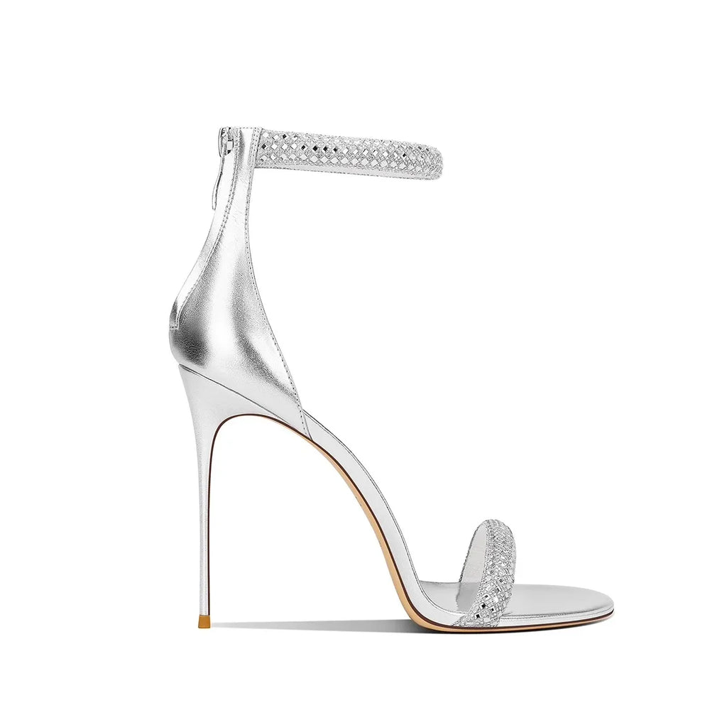 Silver high-heeled sandal with studded details on a white background