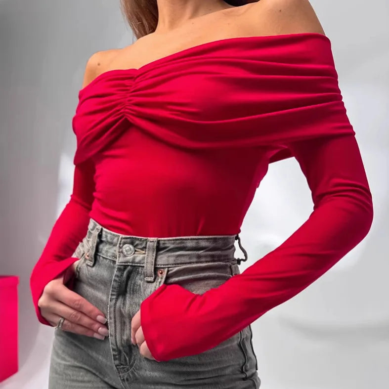 Red off-shoulder top worn by a person on a gray background