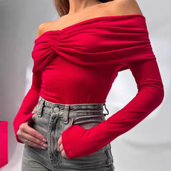 Red off-shoulder top worn by a person on a gray background
