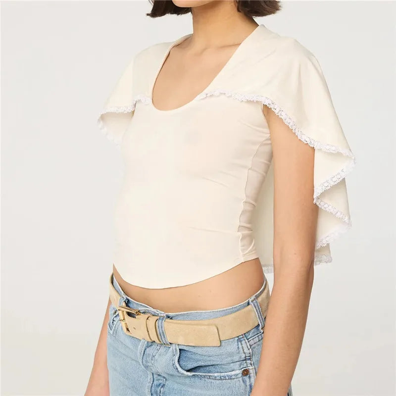 U-neck knit top with white lace trim cape overlay and jeans