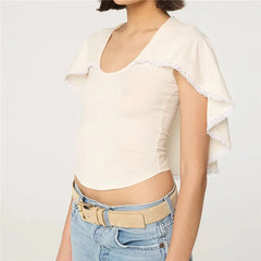 U-neck knit top with white lace trim cape overlay and jeans