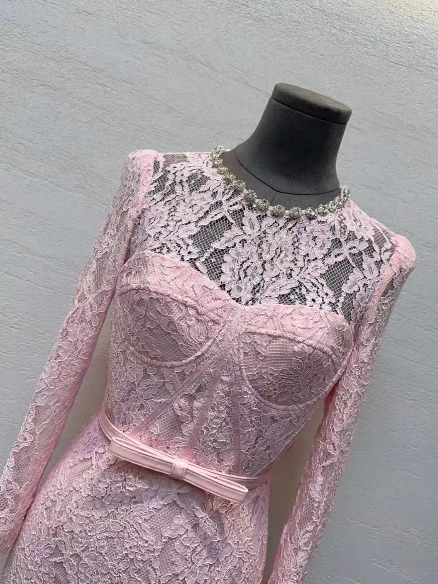 Pink lace dress on a mannequin against a gray background
