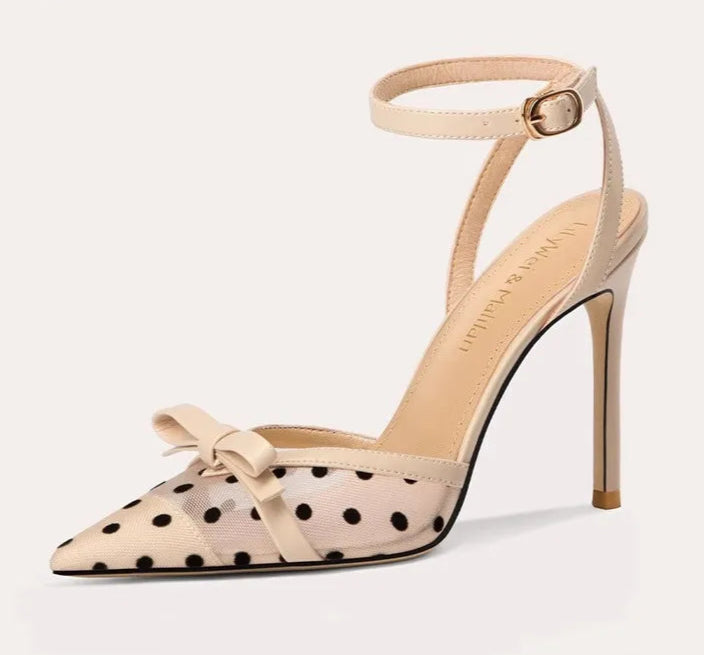 High-heeled shoe with polka dot design and bow detail on a white background