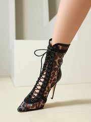 Leopard print high-heeled shoes with lace-up design on a light background