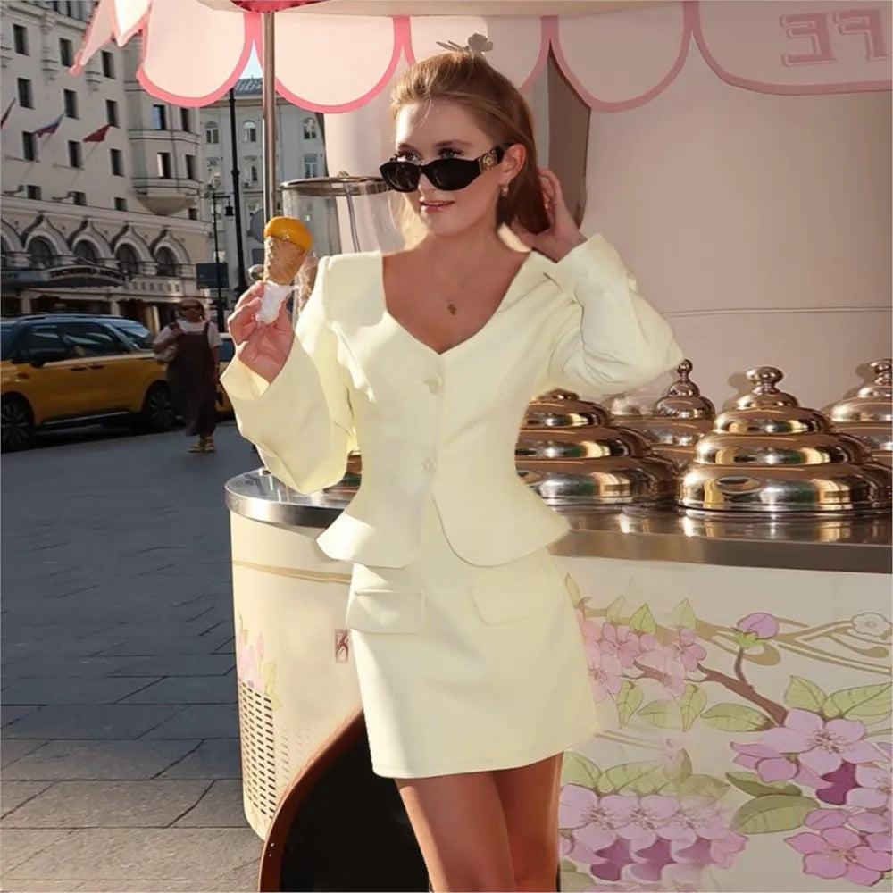 A woman in an apricot outfit is standing next to an ice cream cart with a floral design.