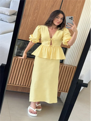 Woman taking a mirror selfie wearing a yellow dress in a living room.