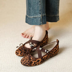 Leopard print Mary Jane flats worn on feet with jeans
