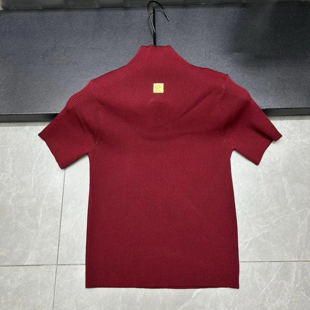 Red sweater on a hanger against a gray background