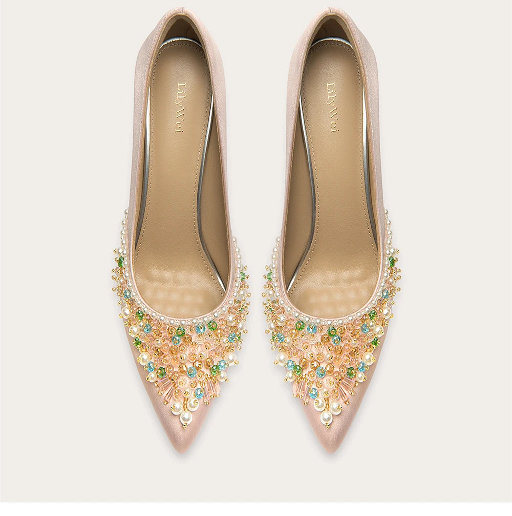 Pair of embellished pink high heels on a light beige background