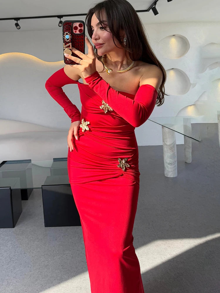 Woman in a red dress with gold embellishments taking a mirror selfie.
