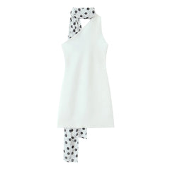 White sleeveless top and polka dot pants on a white background