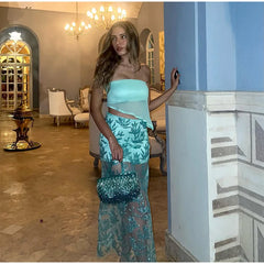 Woman in a teal outfit standing in an elegant interior setting