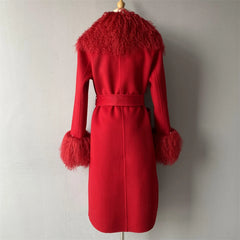 Red coat with feathered collar and cuffs on a mannequin against a plain background