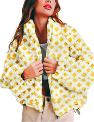 Woman wearing a yellow and white patterned poncho against a white background
