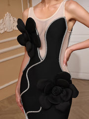 Black dress with floral details worn by a model against a neutral background