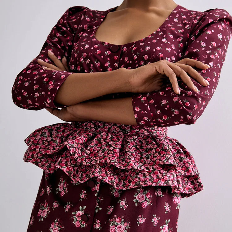 Maroon floral dress with ruffled details on a plain background